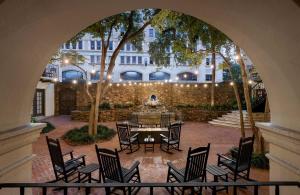 a courtyard with a table and chairs and a building at Omni La Mansion del Rio in San Antonio