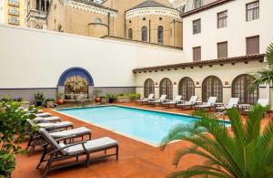 a swimming pool with lounge chairs and a building at Omni La Mansion del Rio in San Antonio