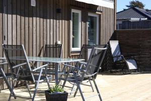 a patio with a table and chairs on a deck at Nybyggd loftstuga i centrala Grebbestad in Grebbestad