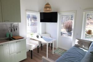 a small kitchen with a table and a small kitchen with a bed at Nybyggd loftstuga i centrala Grebbestad in Grebbestad