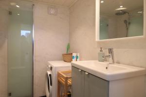 a bathroom with a sink and a mirror and a refrigerator at Nybyggd loftstuga i centrala Grebbestad in Grebbestad +17 photos
