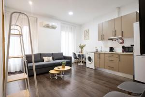 a living room with a couch and a kitchen at Apartamentos Fuencarral II in Madrid +56 photos