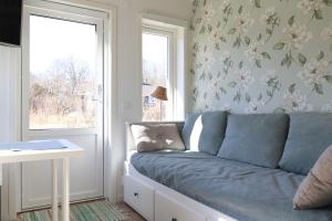 a blue couch in a room with a window at Nybyggd loftstuga i centrala Grebbestad in Grebbestad