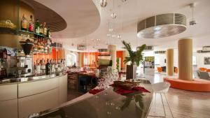 a kitchen with a bar with a glass table in it at Hotel Kaos in Villaggio Pirandello