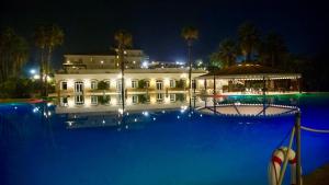 a large building with a swimming pool at night at Hotel Kaos in Villaggio Pirandello