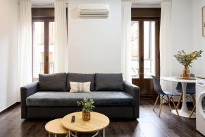 a living room with a couch and two tables at Apartamentos Fuencarral II in Madrid