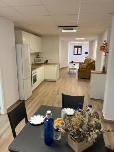 a kitchen and a living room with a table and chairs at Suites TDJ Centro in Torredonjimeno