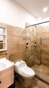a bathroom with a toilet and a glass shower at Basic Hotel Chipichape by Hoteles MS in Cali +29 photos