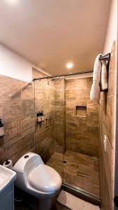 a bathroom with a toilet and a glass shower at Basic Hotel Chipichape by Hoteles MS in Cali