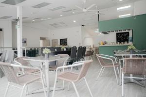 a dining room with white tables and chairs at Basic Hotel Chipichape by Hoteles MS in Cali