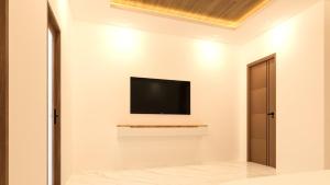 a living room with a television on the wall at TideViewInn in Gaafaru