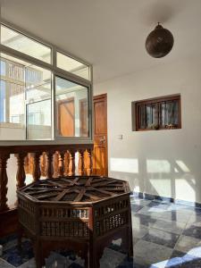 a room with a table and a large window at Dar Bennis médina in Rabat