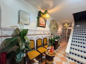 a living room with yellow chairs and a chandelier at Dar Bennis médina in Rabat