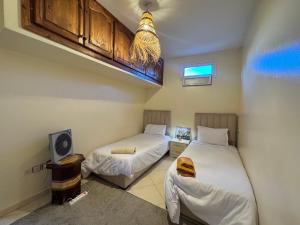 a room with two beds and a tv in it at Dar Bennis médina in Rabat
