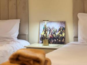 a table with a painting on the wall between two beds at Dar Bennis médina in Rabat