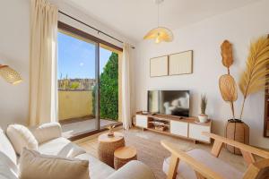 a living room with a tv and a large window at Duquesa Sea & Sun in Manilva