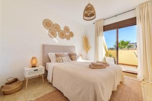 a white bedroom with a bed and a large window at Duquesa Sea & Sun in Manilva +21 photos