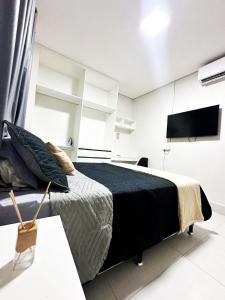 a bedroom with a large bed and a flat screen tv at Lindo flat próximo do centro in Formosa