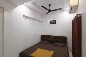 a bed in a room with a ceiling fan at Patel's Guest House in Surat
