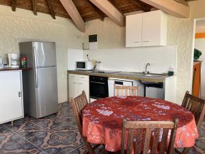 a kitchen with a table and a refrigerator at Résidence" les pas d'Amé" Apt "Ti prune" 2e étage in Les Trois-Îlets +22 photos