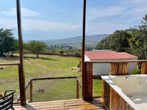 a balcony with a tub and a view of a field at Glamping Barichara in Barichara +13 photos