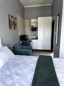 a bedroom with a bed and a couch and a kitchen at Banabaka spa and venue in White River