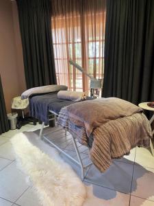 a room with two beds with blankets and a rug at Banabaka spa and venue in White River