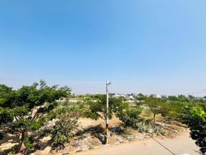 a view of a beach with trees and a pole at Tunga sadan in Mādhavaram