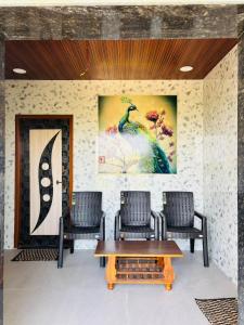 a room with two chairs and a table and a painting at Tunga sadan in Mādhavaram