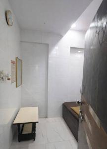 a bathroom with a bench and a tub in it at Patel's Guest House in Surat