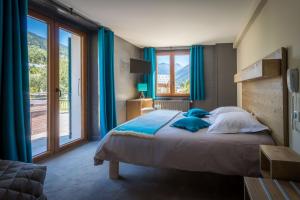 a bedroom with a large bed with blue curtains at hotel le malgovert SEEZ 73 in Séez