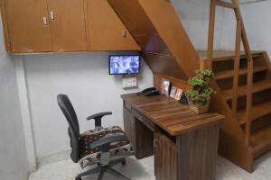 an office with a desk and a chair with a computer at Patel's Guest House in Surat