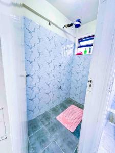 a shower with a pink stool in a bathroom at GILGAL Homes in Kisii +14 photos