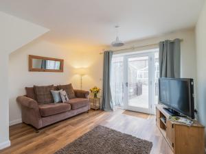 a living room with a couch and a tv at Foxglove - Uk51200 in Staintondale