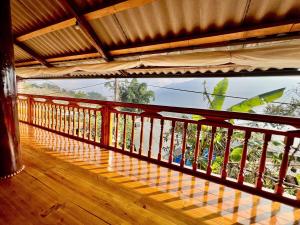 a balcony with a wooden railing and a window at H'mong Village Homestay in Sapa