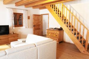 a living room with a white couch and a wooden staircase at Strass4 in Neumarkt-Sankt Veit