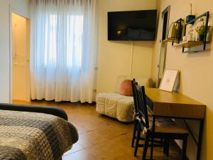 a room with a bed and a desk with a table and a couch at B&B Casa Silingardi in Bagnolo San Vito