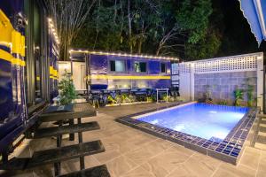 a swimming pool with a train in the background at Baan Rot Fai Krabi Platform 3 in Ao Nam Mao