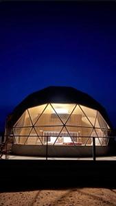 a domed building with a black roof at night at Silent Sands in Wadi Rum