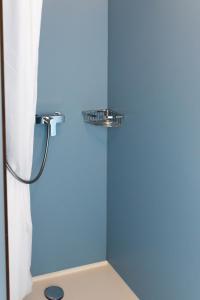 a bathroom with a shower with a blue wall at Grand Hotel du Cervin - Auberge de jeunesse et spa in Saint-Luc +35 photos