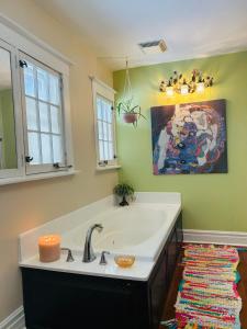 a bathroom with a sink and a painting on the wall at The Farmhouse Manor B&B in St. Catharines +93 photos