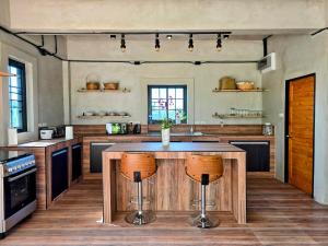a kitchen with a center island in a room at Anusorn Villas & Garden Oasis - Peaceful Chiang Mai Hideaway in Ban Ton Chok
