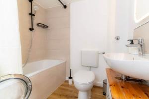 a bathroom with a sink and a toilet and a bath tub at Lykke Suite in Handewitt +14 photos