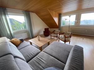 a living room with a couch and chairs and windows at 3-Zimmer-Ferienwohnung in Werl