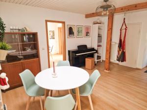 a living room with a table and chairs and a piano at Himmelsnest in Bad Wildbad