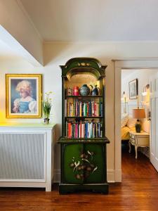 a green book shelf with books in a room at The Farmhouse Manor B&B in St. Catharines