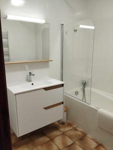 a white bathroom with a sink and a shower at Gîte de St Jean in Verdalle +3 photos