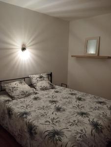 a bedroom with a bed with a blanket with plants on it at Gîte de St Jean in Verdalle