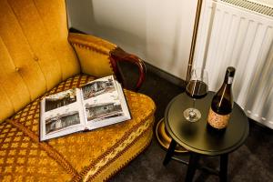 a table with a bottle of wine and a glass at Dworek Modrzewiowy in Kraśnik