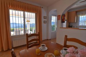 a kitchen and dining room with a table and windows at Villa La Frasca with private Pool in Corumbela